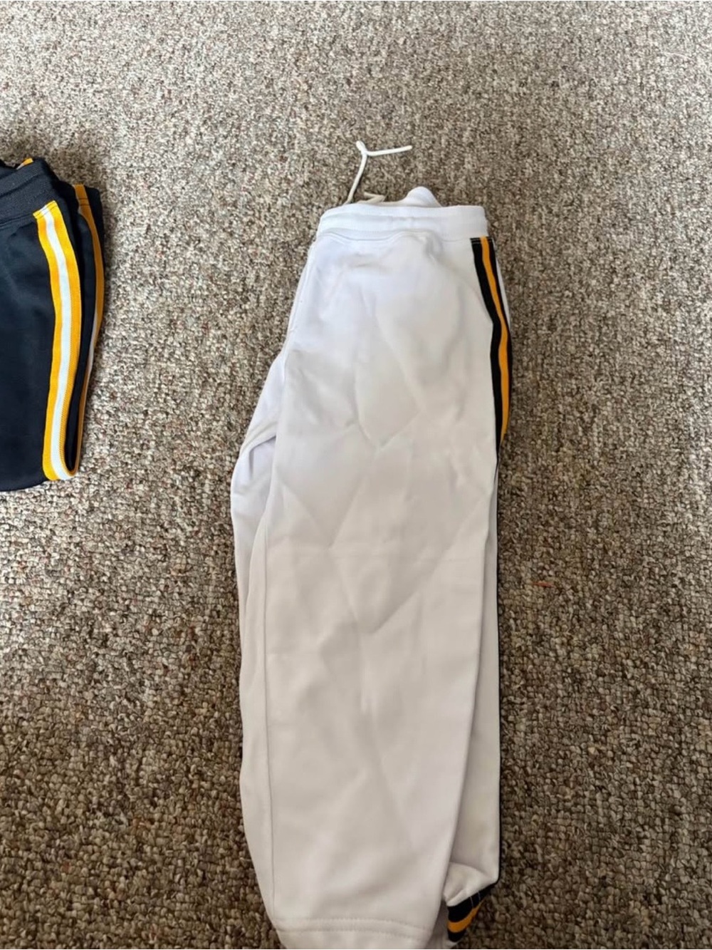 White softball pants with gold and black side
